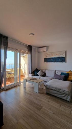 uma sala de estar com um sofá e uma mesa em PALM TOWER APARTMENT em Roquetas de Mar