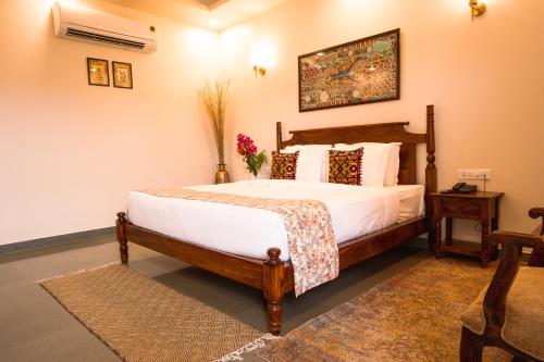 a bedroom with a bed with white sheets and pillows at RajBagh by Aaryam in Sawāi Mādhopur