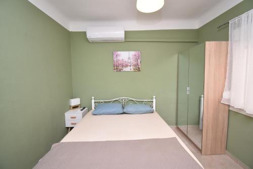 a bedroom with a bed in a room with green walls at Prive Apartment Thessaloniki-Easy Parking in Thessaloniki