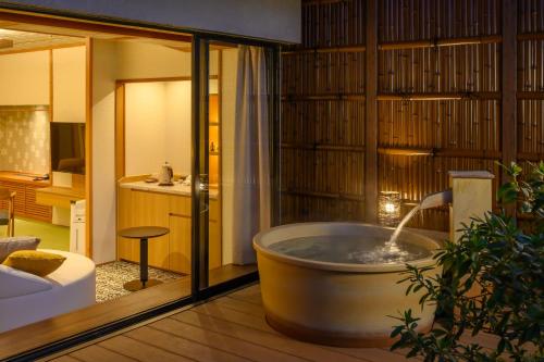 a bath tub in a room with a bathroom at Fukuichi in Shibukawa