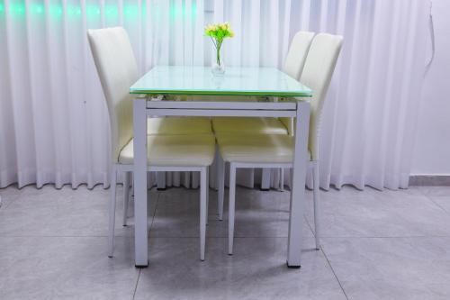 a table with two chairs and a vase with flowers on it at דירת יהלום חדשה ומודרנית 5 דקות נסיעה מהים in Ashqelon