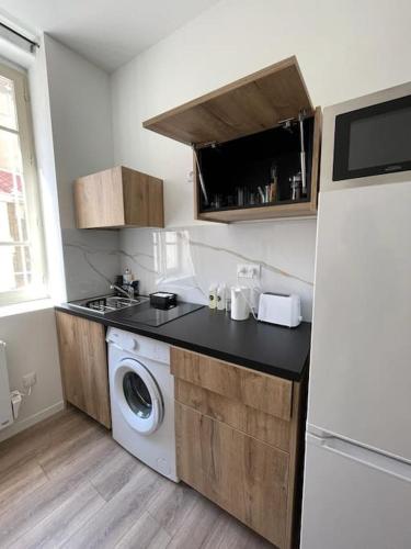 una cucina con lavatrice e frigorifero di T1 Contemporain Proche du stade appart 101 a Saint-Étienne