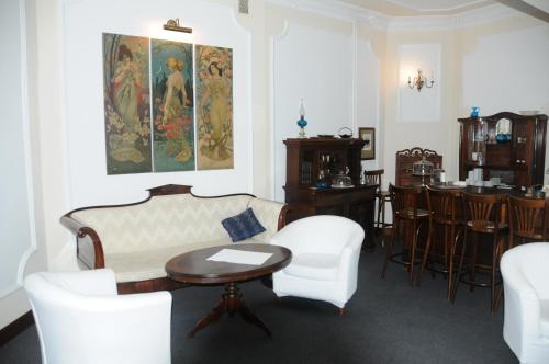 a living room with a couch and a table and chairs at Czerwony Dwór in Krynica Zdrój
