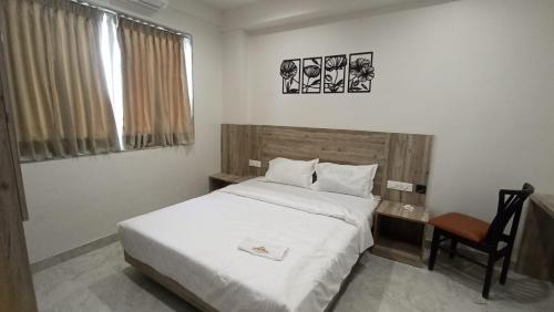 a bedroom with a bed and a desk and a chair at Hotel Jay Palace Inn in Solapur