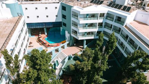 阿基歐斯尼古拉斯的住宿－Santa Marina Unique Hotel，享有带游泳池的大楼的顶部景致