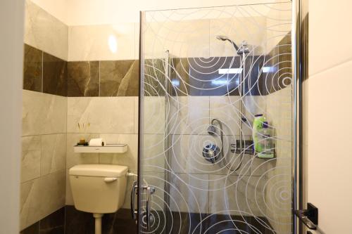 a bathroom with a toilet and a glass shower at דירת יהלום חדשה ומודרנית 5 דקות נסיעה מהים in Ashqelon
