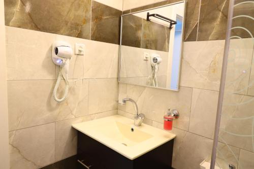 a bathroom with a sink and a phone on the wall at דירת יהלום חדשה ומודרנית 5 דקות נסיעה מהים in Ashqelon