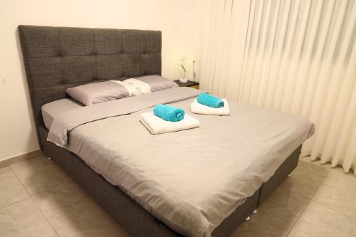 a bedroom with a large bed with two pillows on it at דירת יהלום חדשה ומודרנית 5 דקות נסיעה מהים in Ashkelon