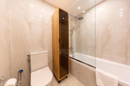 y baño con aseo, ducha y lavamanos. en Charming Brand New 2BR close to the Beach en Dubái