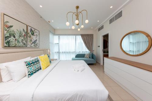 Charming Brand New 2BR close to the Beach في دبي: غرفة نوم بسرير ابيض كبير ومرآة
