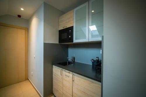 a kitchen with a sink and a microwave at Eleven Business & Sport Hotel in Jászárokszállás