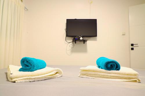 two towels sitting on top of a table with a tv at דירת יהלום חדשה ומודרנית 5 דקות נסיעה מהים in Ashqelon
