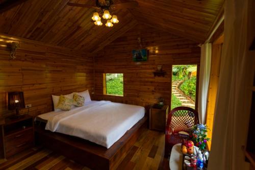 O'chau Homestay Sapa في لاو كاي: غرفة نوم بسرير في كابينة خشبية