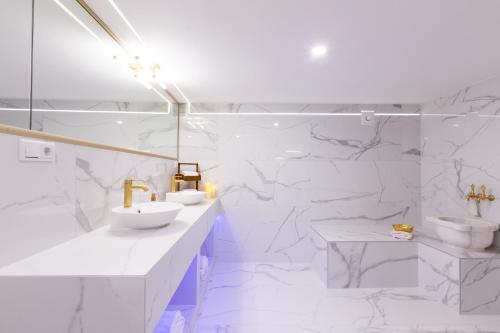 a white bathroom with two sinks and two toilets at Hevals Spa & Design Apartment in Berlin