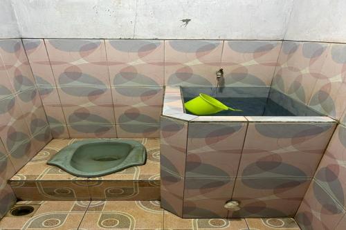 a bathroom with a green toilet and a sink at OYO Life 92982 Kost Berkah Ibu in Lawang