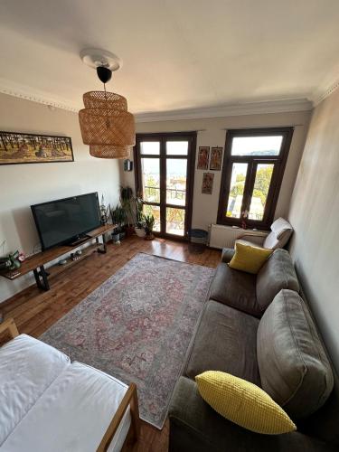 sala de estar con sofá y TV de pantalla plana en Historic Wooden House with Bosphorus view en Sarıyer