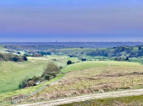 a green field with a fence on a hill at Beautiful Character Property in Angmering