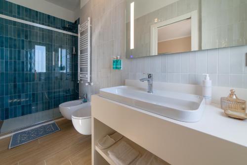 ein Badezimmer mit einem Waschbecken, einem WC und einem Spiegel in der Unterkunft Hotel Sporting in Vasto