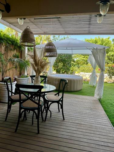 patio con tavolo, sedie e ombrellone di Habostan ceasarea, הבוסתן בקיסריה a Caesarea