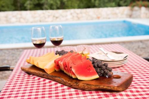 查普利納的住宿－Villa Stanko Međugorje，桌上一盘水果和两杯葡萄酒