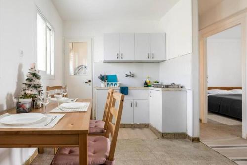 a kitchen and dining room with a table and a room with a bed at "One minute from sea" from Shneider Apartments in Haifa