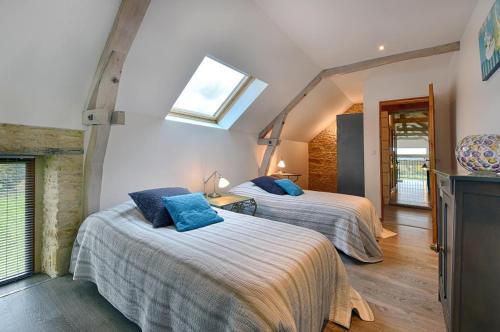 a bedroom with two beds and a skylight at La Grange 