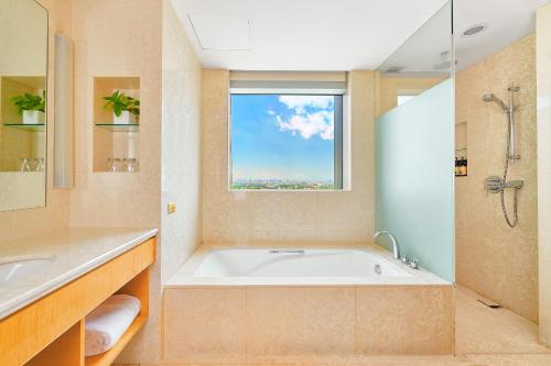a large bathroom with a tub and a window at Windsor Hotel Taichung in Taichung