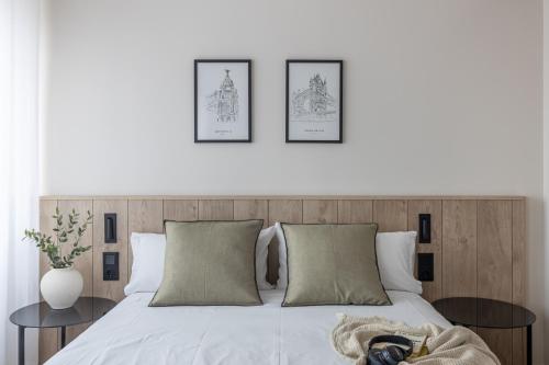 1 dormitorio con 1 cama blanca y 3 cuadros en la pared en Líbere Madrid Chamberí en Madrid