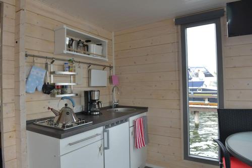 a kitchen in a tiny house with a sink at Hausboot NautikHus auf der Havel in Kolonie Zern