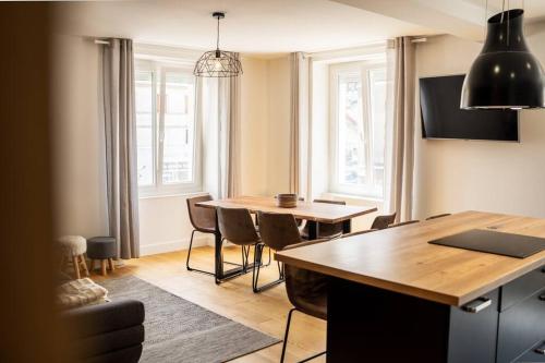 une cuisine avec une table et des chaises dans une pièce dans l'établissement L'appart' du dessous, à Gérardmer