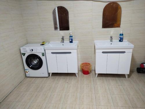 a laundry room with two sinks and a washing machine at Gold Hostel in Tashkent
