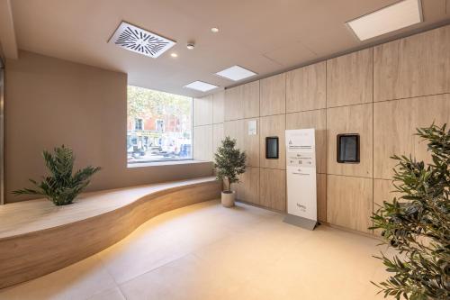una sala d'attesa con piante e una finestra di Líbere Madrid Chamberí a Madrid