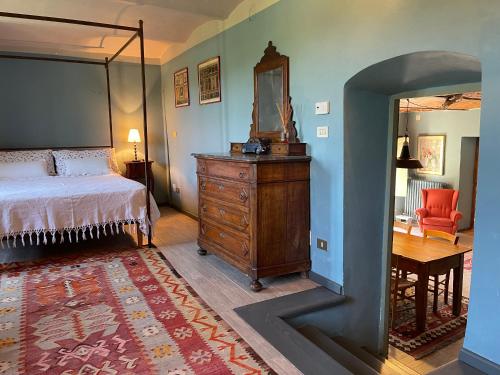 Schlafzimmer mit einem Bett, einer Kommode und einem Spiegel in der Unterkunft La Verbia in Sciolze