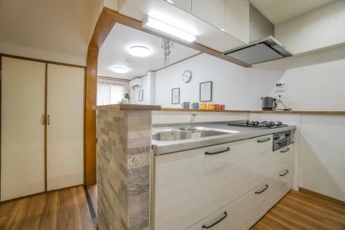 a kitchen with a sink and a counter top at HANASTAY花渓居 野田Noda in Osaka