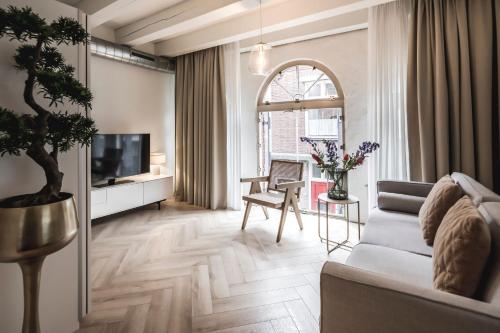 a living room with a couch and a tv at Le Bon'Apart Suites in Gorinchem