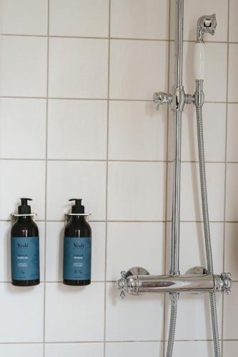 two bottles ofodorizers sitting on a wall in a bathroom at Rye115 Hotel in Copenhagen
