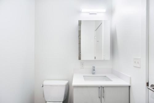 a white bathroom with a toilet and a sink at Central Sq 3BR w WD nr MIT Kendall Sq BOS-367 in Cambridge