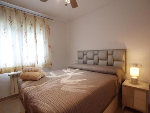 a bedroom with a bed with a lamp and a window at Villa Amyali by Rentalole Mar Menor Golf Resort in Torre-Pacheco