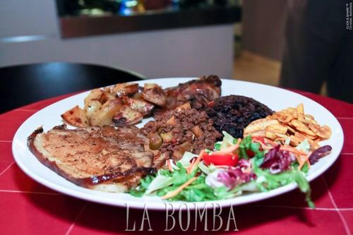 a plate of food with meat and salad on a table at Hotel Cubamia in Romano D'Ezzelino