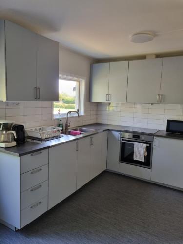 a kitchen with white cabinets and a sink at Nyckelbo Vandrarhem in Helsingborg