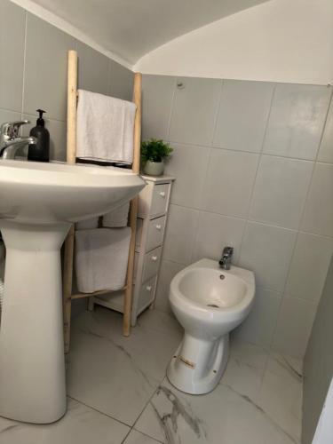 a white bathroom with a sink and a toilet at [Verdesera] Idromassaggio, Netflix, Wifi a Porta Susa in Turin