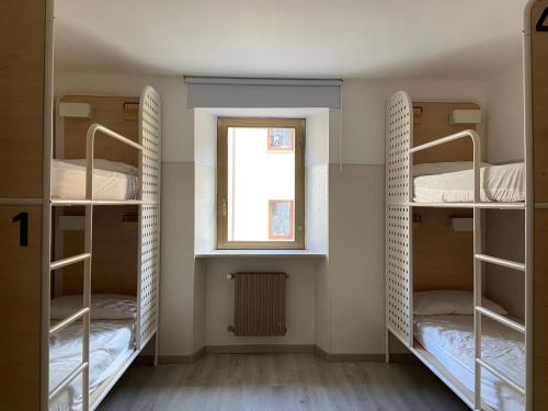 Ce dortoir comprend 2 lits superposés et une fenêtre. dans l'établissement HostHello Nus, à Nus