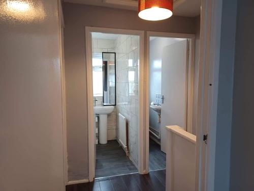 a bathroom with a sink and a mirror at Poynters House - Huku Kwetu Luton & Dunstable - Spacious 2 Bedroom- Suitable & Affordable Group Accommodation - Business Travellers in Luton