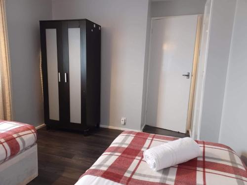 a bedroom with a bed with a towel on it at Poynters House - Huku Kwetu Luton & Dunstable - Spacious 2 Bedroom House-Private garden and parking in Luton