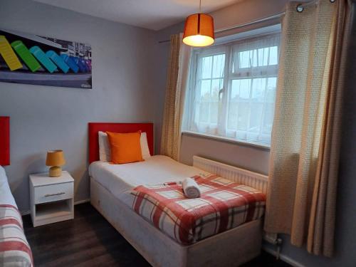 - une petite chambre avec un lit et une fenêtre dans l'établissement Poynters House - Huku Kwetu Luton & Dunstable - Spacious 2 Bedroom- Suitable & Affordable Group Accommodation - Business Travellers, à Luton
