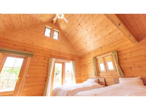 a bedroom with two beds in a wooden cabin at Lagasis Ishigaki Nosako Villa - Vacation STAY 74548v in Ibaruma