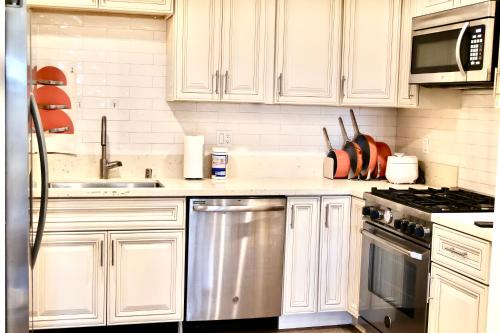 uma cozinha com armários brancos e electrodomésticos de aço inoxidável em Best location and value em Pasadena