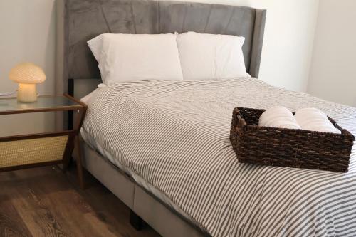 a bed with a basket of pillows next to a table at Best location and value in Pasadena