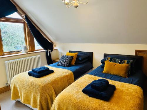 een kamer met 2 bedden met gele lakens en een bank bij Poet's Cottage, Steep - Rural Location - Sleeps 6 in Steep