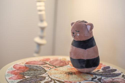 un chat en jouet assis au-dessus d'une table dans l'établissement Le Rhône, à Annecy